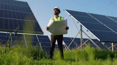 Enerji santralindeki güneş panellerini denetleyen genç Hintli mühendis - profesyonel işgal, yenilenebilir enerji ve teknoloji kavramı.