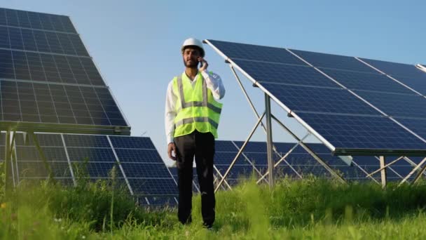 Індійський Інженер Розмовляє Смартфоном Перед Сонячною Панеллю — стокове відео