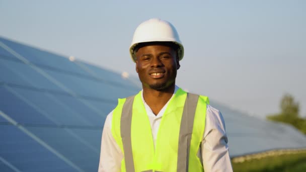 Güneş Panellerinin Yanındaki Miğferde Afrikalı Mühendisin Portresi Güneş Enerjisi Santralinde — Stok video