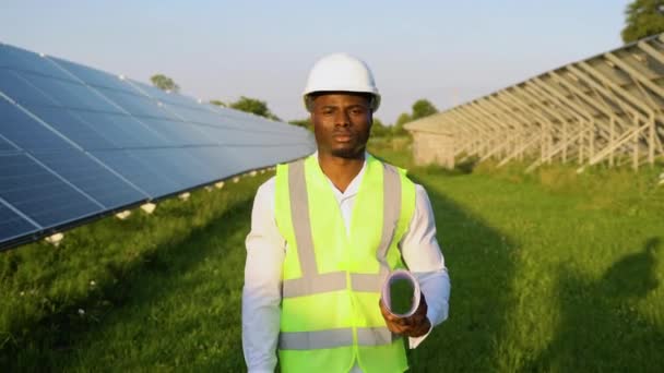 発電所で太陽光パネルを点検する若い黒人エンジニア 専門職の職業 再生可能エネルギーおよび技術の概念 — ストック動画