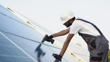 Çatıya güneş panelleri kuran bir işçi