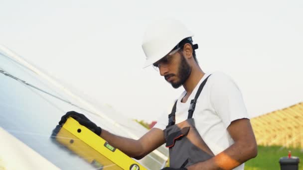 用可持续能源发电厂的水平工具安装太阳能电池板的专业印度工人 — 图库视频影像
