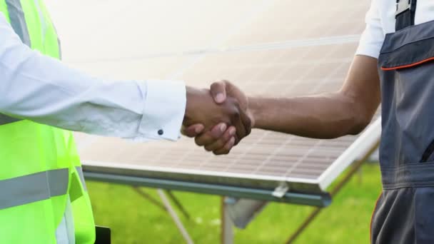 ソーラーパネルの前で握手するエンジニア — ストック動画