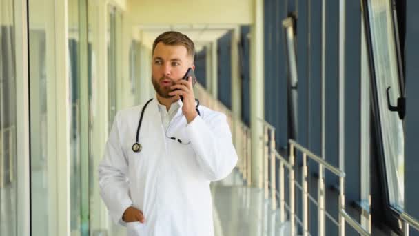 Dokter Memberikan Konsultasi Medis Pasien Melalui Ponsel Koridor Rumah Sakit — Stok Video