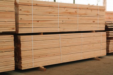 büyük bir depoda kereste. Yığındaki ahşap panoları.