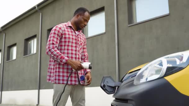 Zwarte Man Laadt Lading Elektrische Auto Buurt Van Magazijn Groene — Stockvideo