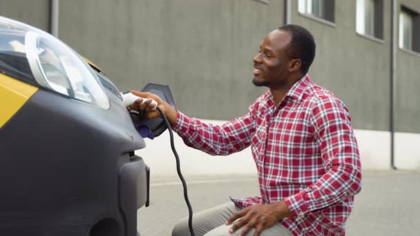 Afrikanischer Mann Kappt Stromstecker Elektroauto — Stockvideo