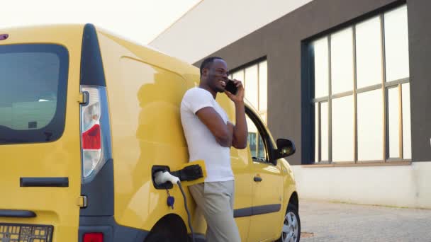 Schwarzer Mann Telefoniert Beim Laden Von Ladewagen Ladestation Für Elektrofahrzeuge — Stockvideo