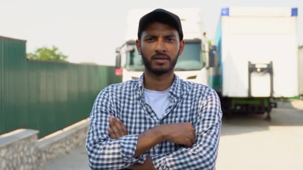 カジュアルな服を着たインドのトラック運転手は 彼のトラックのそばに立っている十字の腕を持っています トランスポートサービス — ストック動画