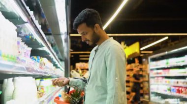 Süt alan yakışıklı Hintli adam. Bakkalda mandıra ürünü satan bir adam..