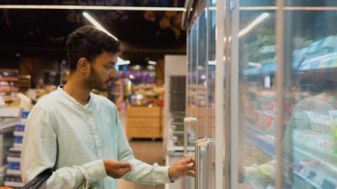 Hintli Asyalı adam bıldırcın yumurtası alırken marketten alışveriş yapıyor..