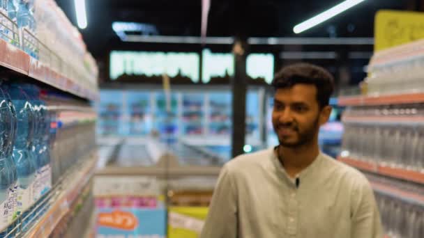 Jóképű Indiai Srác Kezében Bevásárlókosár Vásárol Ásványvíz Szupermarketben — Stock videók