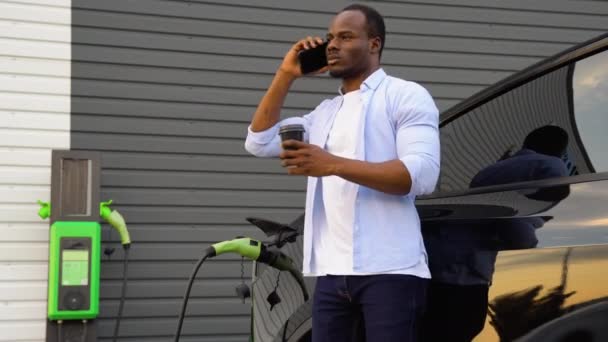 Щасливий Молодий Чорний Чоловік Заряджає Автомобільну Батарею Маленької Громадської Станції — стокове відео