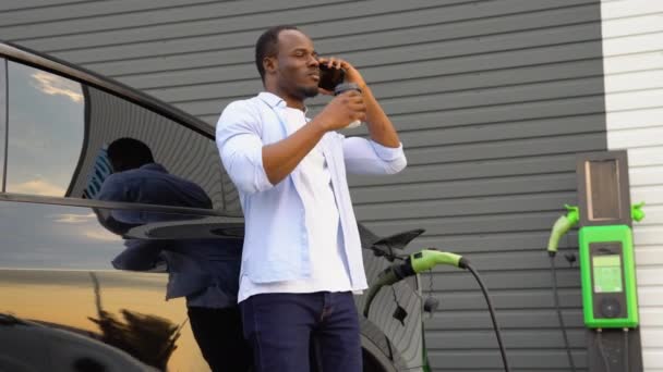 Щасливий Молодий Чорний Чоловік Заряджає Автомобільну Батарею Маленької Громадської Станції — стокове відео