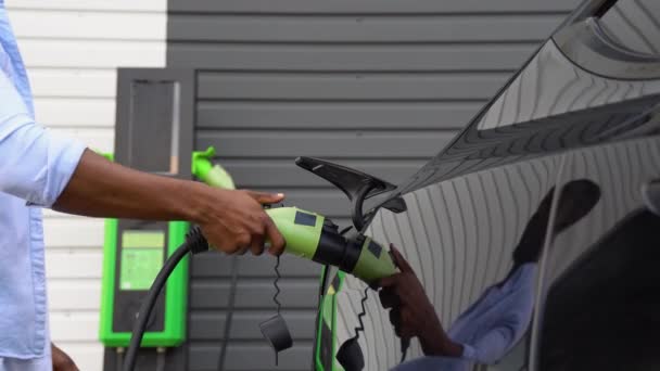 Unbekannter Schwarzer Mann Zieht Ladekabel Für Elektroauto Grüne Energie Umweltfreundlicher — Stockvideo