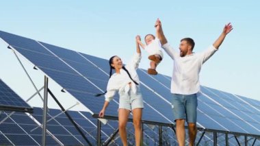 Güneş panellerinin yanında yürüyen aile, yeşil yaşam konsepti