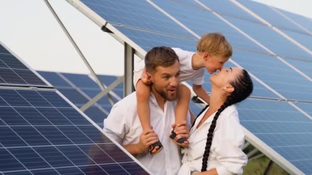 3人の若い家族は 太陽光発電パネル 微笑み 明るい未来のコンセプトの近くに休んでいる — ストック動画