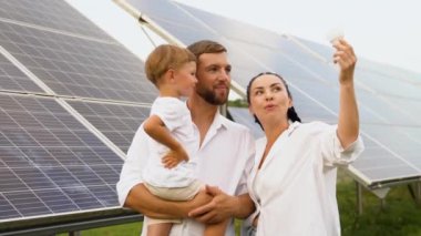 Güneş panelleri yakınında ampullü bir aile.