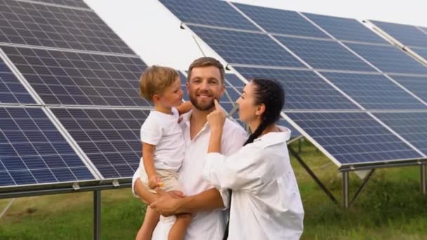 Μια Νέα Τριμελής Οικογένεια Αναπαύεται Κοντά Φωτοβολταϊκούς Ηλιακούς Συλλέκτες Χαμογελώντας — Αρχείο Βίντεο