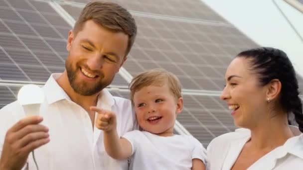 Perhe Hehkulamppu Lähellä Aurinkopaneelit — kuvapankkivideo
