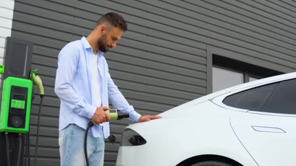 Człowiek Podłącza Kabel Ładowania Pojazdu Elektrycznego Ładuje Baterie Stacji — Wideo stockowe