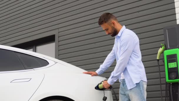 駅でケーブル電気自動車を充電する男のアンプラグ グリーンエネルギー 環境に優しい燃料 — ストック動画