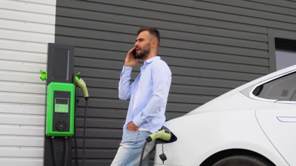 Een Man Aan Telefoon Terwijl Hij Een Luxe Elektrische Auto — Stockvideo