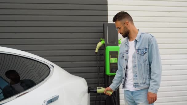 Ein Mann Zieht Bahnhof Das Ladekabel Grüne Energie Umweltfreundlicher Kraftstoff — Stockvideo