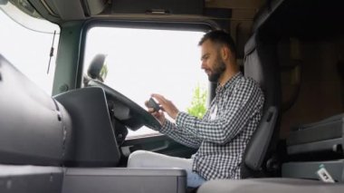 Hedefe mal taşımak ve taşımak için kamyonet GPS 'i kullanan profesyonel bir kamyoncu. Ulaşım hizmetleri. Sağ el sürücüsü araba.