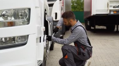 Araba servisinde kamyon lastiğini değiştirirken soket anahtarı kullanan profesyonel bir tamirci..