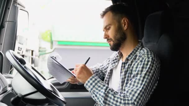 Deliveryman Κάθεται Στο Φορτηγό Και Τον Έλεγχο Της Λίστας Των — Αρχείο Βίντεο