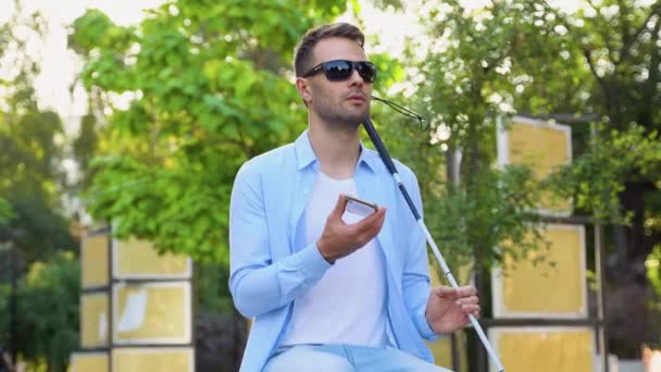 Τυφλός Φοράει Γυαλιά Ηλίου Κρατώντας Λευκό Μπαστούνι Και Μιλώντας Στο — Αρχείο Βίντεο