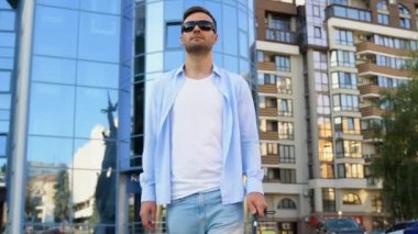 Yakışıklı kör adam kasabada sopayla yürüyor..