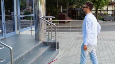 Kör bir adam binaya giriyor.