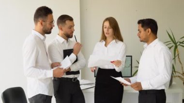 Çeşitli iş adamları şirket ofisinde birlikte çalışıyor..