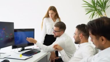 Modern bir çalışma alanında birlikte çalışırken bilgisayar kullanan bir grup iş adamı..