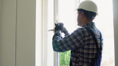 Hintli işçi eve pencere kurup kontrol ediyor