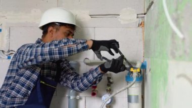 Hintli tesisatçı yeni daireye su filtresi kuruyor ya da değiştiriyor. Yerleştirme su filtresi.