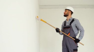 Profesyonel dekoratör ışık duvarı boyuyor..