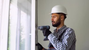 Yeni evdeki pencere kurulumunda sanayi inşaat işçisi.