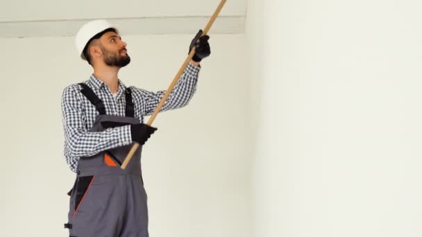 Ein Mann Arbeiter Bemalt Wand Mit Weißem Farbstoff Innenräumen — Stockvideo