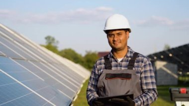 Güneş panelleri istasyonunda dijital tabletli Hintli mühendisin portresi.