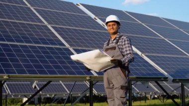 Enerji santralindeki güneş panellerini inceleyen Hintli mühendis.