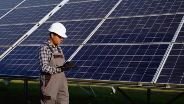 太陽電池パネルの発電所で働くデジタルタブレットを保持するインドの検査エンジニア — ストック動画