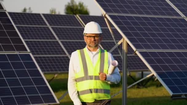 太阳能发电厂保护头盔行走和检查光伏面板的50名高级工程师 — 图库视频影像