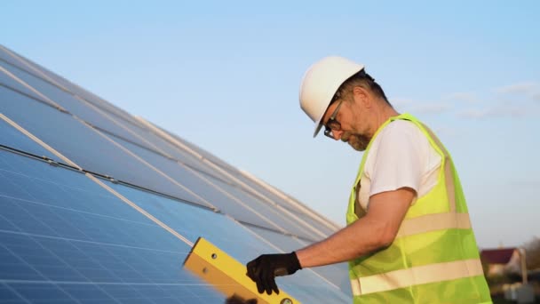 Senior Man Technician Mounting Photovoltaic Solar Modules Station Level Tool — Stock Video