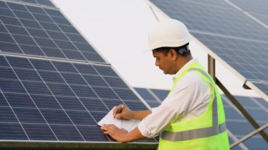 Koruyucu miğferdeki Hintli mühendis, kurulumdan sonra Güneş İstasyonu 'nun teknik belgelerini kontrol ediyor..