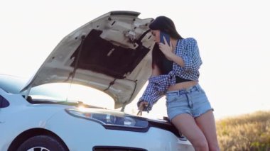 Çaresiz genç bir kadın yolda bozuk bir arabanın yakınından acil yardım çağrısı yapıyor. Yolda araba arızası..