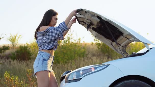 Νεαρή Γυναίκα Κοιτάζει Κάτω Από Καπό Του Σπασμένου Αυτοκινήτου Της — Αρχείο Βίντεο