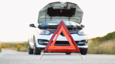 Sorunlu bir araba ve diğer yol kullanıcılarını uyarmak için kırmızı bir üçgen. Ulaşım, seyahat kavramı